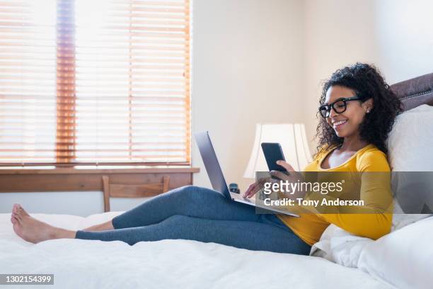 young woman working from home with laptop and phone - businesswoman barefoot stock-fotos und bilder