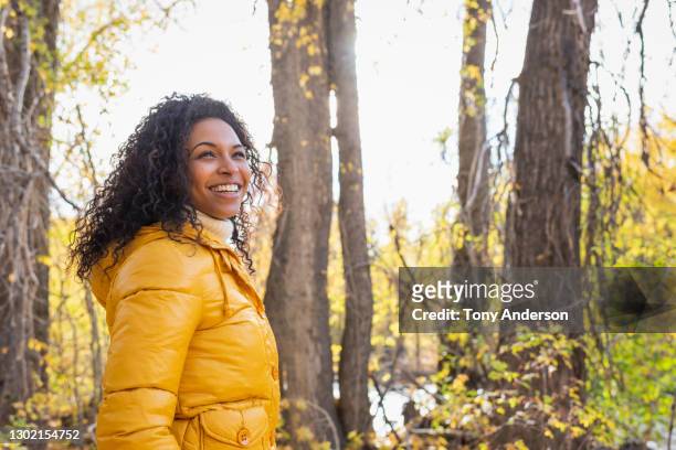 young woman in autumn woods - geel jak stockfoto's en -beelden