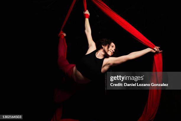 flexible woman hanging in aerial straps during yoga session - strap stock pictures, royalty-free photos & images