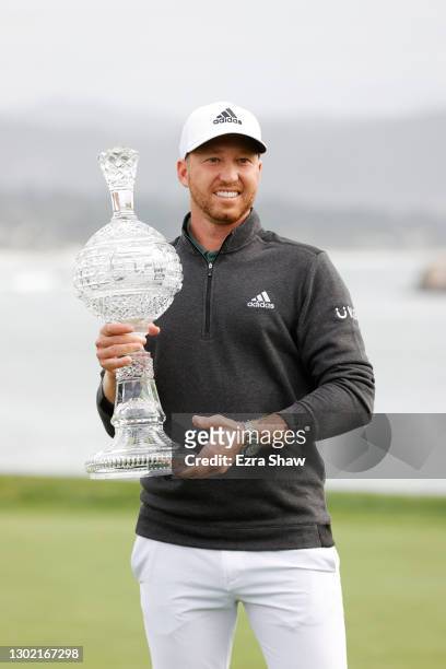 Daniel Berger of the United States celebrates with the trophy after winning during the final round of the AT&T Pebble Beach Pro-Am at Pebble Beach...
