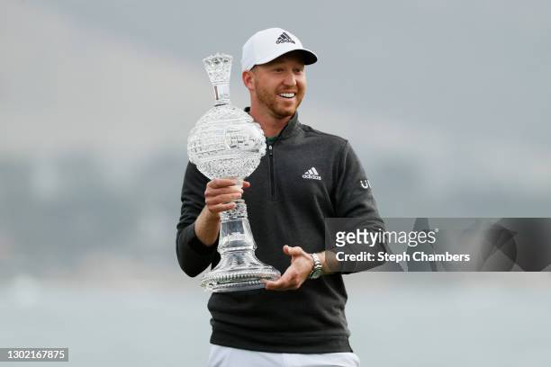 Daniel Berger of the United States celebrates with the trophy after winning during the final round of the AT&T Pebble Beach Pro-Am at Pebble Beach...