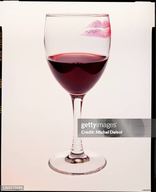 Glass of red wine with a lipstick mark, on a light background. Originally photographed for Mademoiselle magazine. New York, New York. December 16th,...