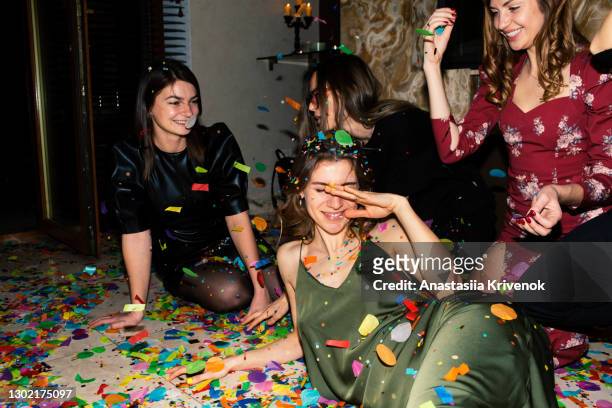 group of friends having fun with confetti at home. - room after party fotografías e imágenes de stock