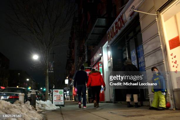 Couple holds hands walking through on Valentine's Day on February 14, 2021 in the Brooklyn borough of New York City.