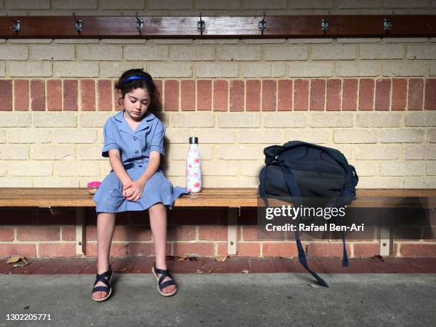 sad bullied young girl sitting alone on bench - first day of school australia stock pictures, royalty-free photos & images