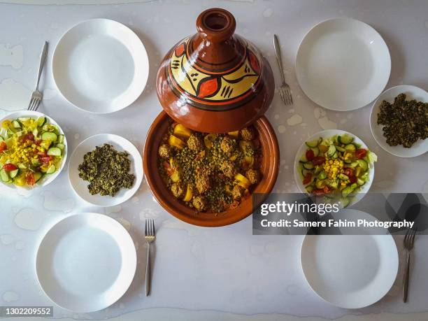 high angle view of food served on table (tagine of peas and potatoes with meatballs, salad and spinach) - tajine stock pictures, royalty-free photos & images