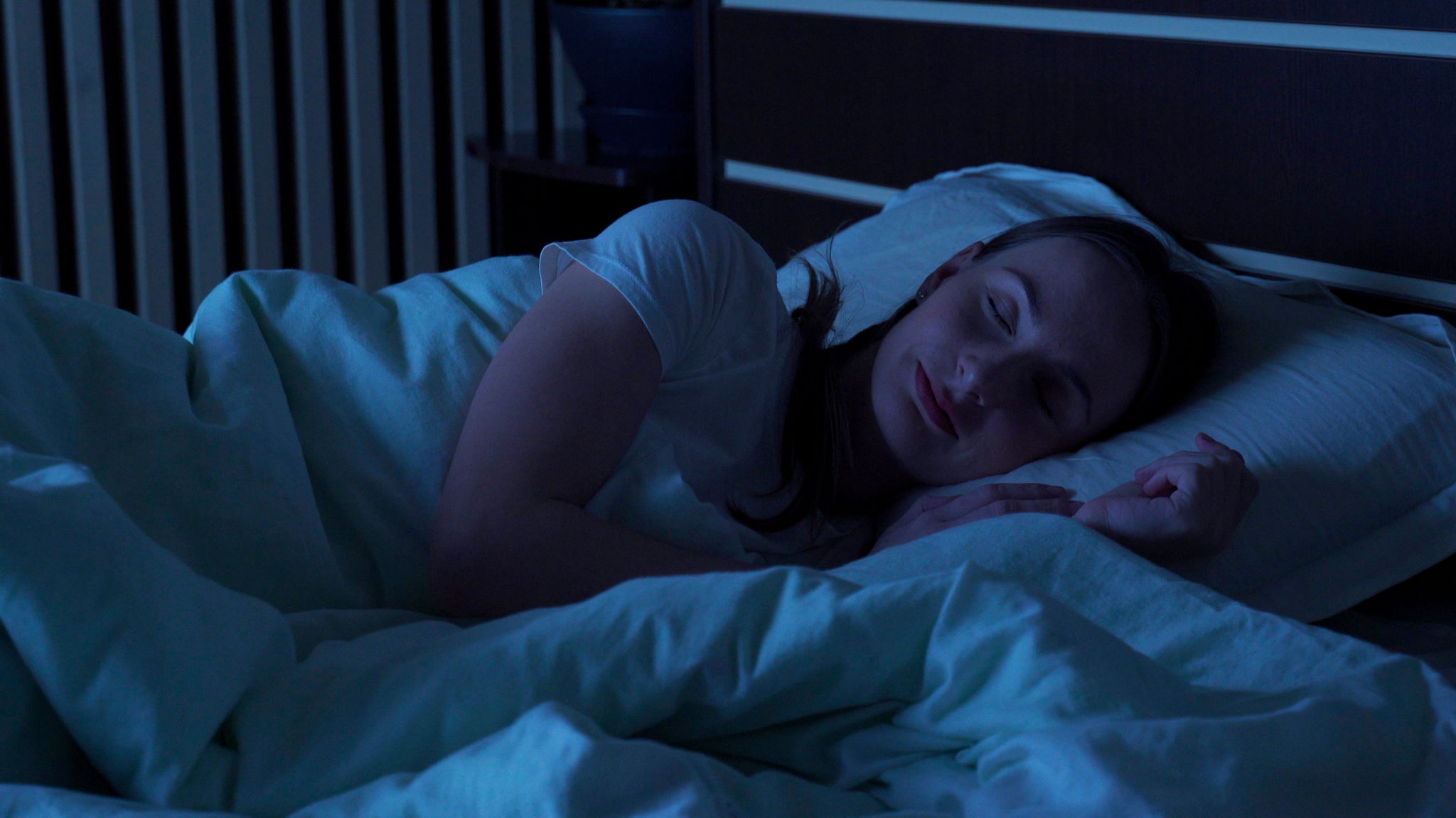 Young woman comfortably sleeping at night in a bed at home. Sleep time Young woman comfortably sleeping at night in a bed at home. Sleep time