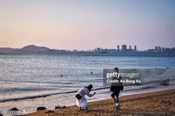 Couple visits a beach on which anti-tank fortifications from previous conflicts line the shore on February 04, 2021 in Lieyu, an outlying island of...