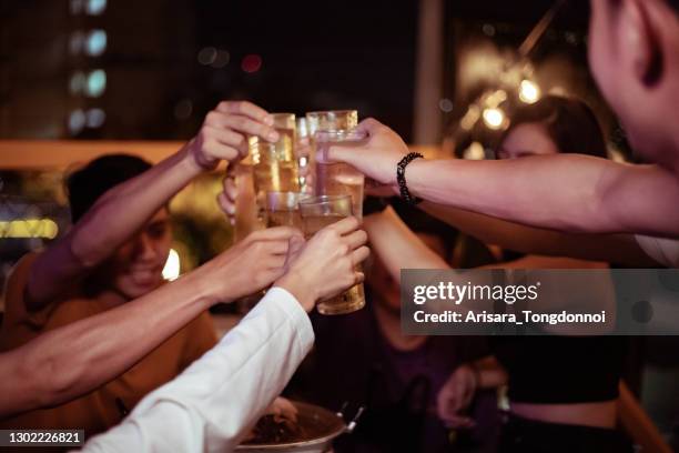 gruppo di giovani mani che brindano e tifano per le birre da aperitivo - alchol foto e immagini stock