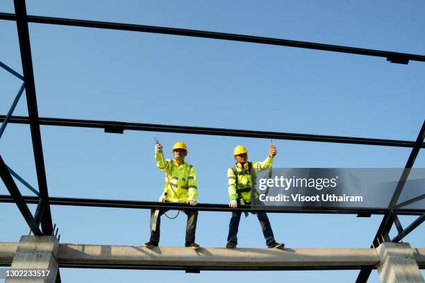 construction worker installation steel roof. - holzbalken stock-fotos und bilder