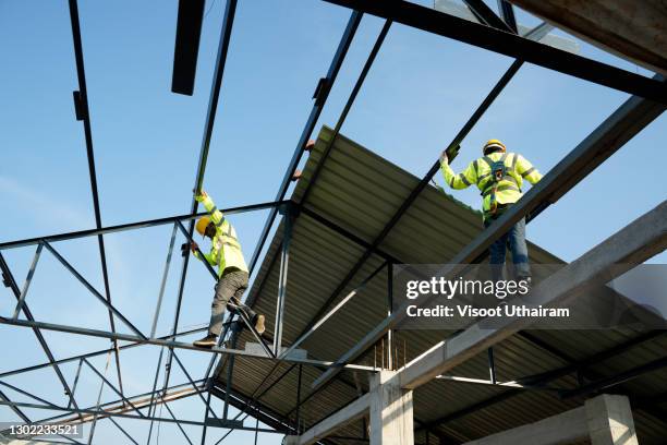 worker install steel roof sheet for new roof. - dakdekker stockfoto's en -beelden