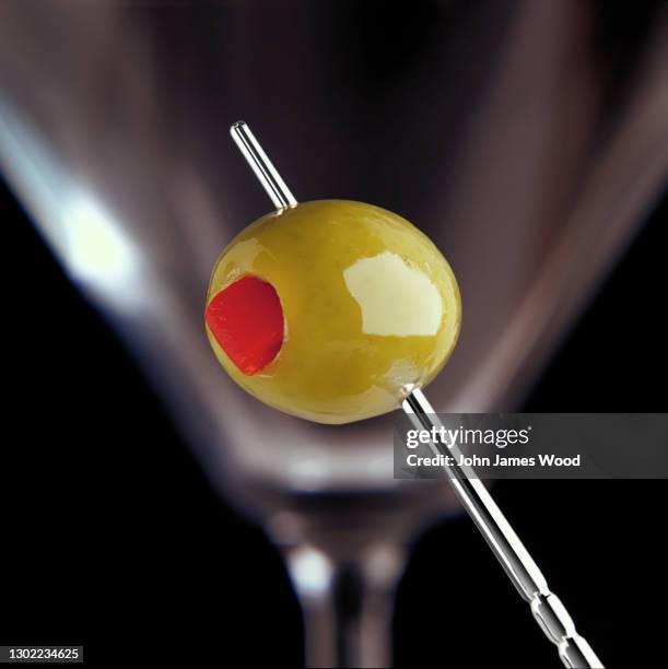 stuffed olive on a silver cocktail stick close-up - olive pimento stock pictures, royalty-free photos & images