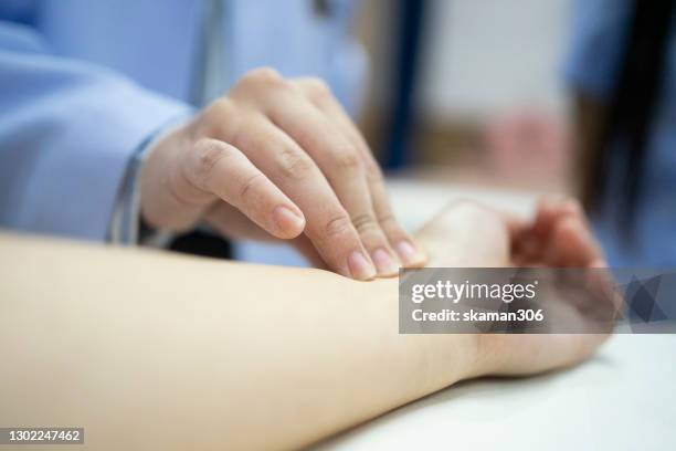 chinese female doctor checking pulse patient at hospital - taking pulse stock pictures, royalty-free photos & images