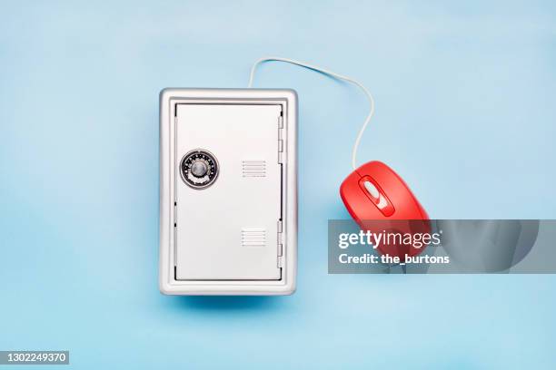 still life of a safe and computer mouse on blue background - safe data stockfoto's en -beelden