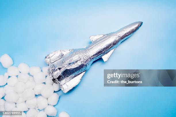 still life of a selfmade rocket and white cotton balls on blue background - model rocket stock pictures, royalty-free photos & images