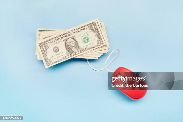 high angle view of american dollar banknotes and computer mouse on blue background - computer mouse definition fotografías e imágenes de stock