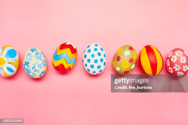 directly above shot of colourful painted easter eggs on pink background - 復活蛋 個照片及圖片檔