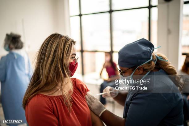 adolescente que está siendo vacunada - usando máscara facial - inmunologia fotografías e imágenes de stock