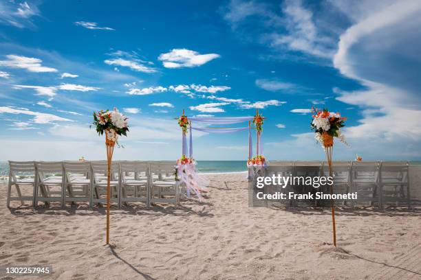 wedding ceremony preparation of chairs and flowers for beach wedding - outdoor wedding ceremony stock pictures, royalty-free photos & images