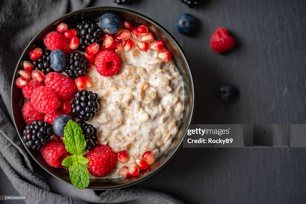 Organic Oatmeal topped with Raspberries, Blueberries, Blackberries and Pomegranate Seeds and Mint Leaves