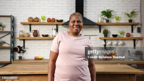 african-american lady in t-shirt looks straight and smiles - woman look straight black shirt stock pictures, royalty-free photos & images