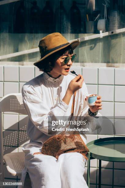 portrait of a young thai woman dressed in white sitting and eating ice cream - elegant spoon stock pictures, royalty-free photos & images