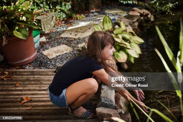 happy girl at garden pond - garden pond stockfoto's en -beelden