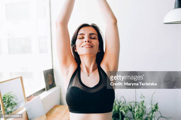 young woman goes in for sports at home. - scapula stock pictures, royalty-free photos & images