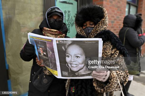 Guests read a newspaper with Cicely Tyson on the front page as they wait in line to pay their respects to the late Cicely Tyson at a public viewing...