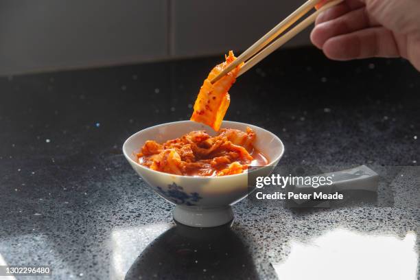 eating korean kimchi - plato de acompañamiento fotografías e imágenes de stock