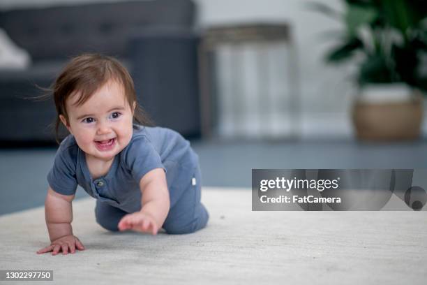 cute baby girl is learning to crawl - six month old stock pictures, royalty-free photos & images