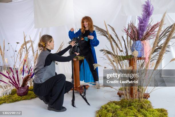 two artist women preparing a flowers still life decoration on ceramic sculpture vase - art installation stock pictures, royalty-free photos & images