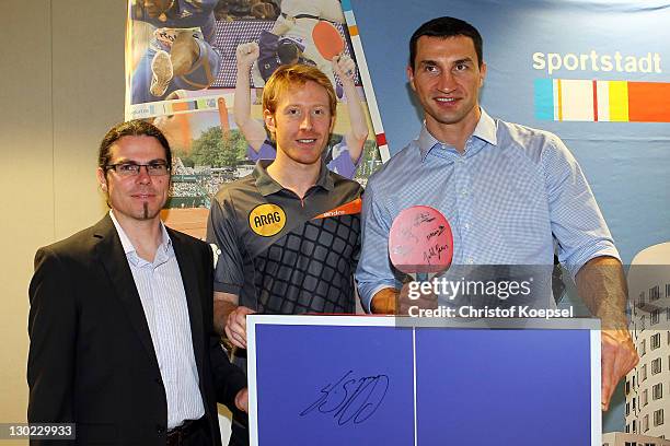 Press speaker Alexander Schillings of Borussia Duesseldorf and Christain Suess hand out a gift to Wladimir Klitschko during the meeting of table...