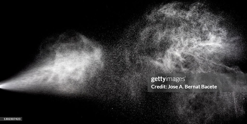 Collision of two pressurized water jets on a black background.