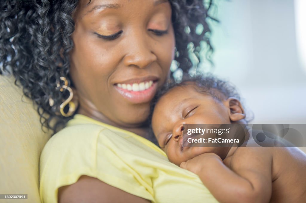 Neonato che dorme sul petto della madre