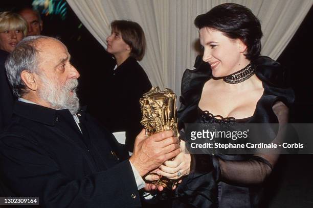 Sculptor Cesar and actress Juliette Binoche who poses with her Cesar for the Best Actress for "Trois couleurs: Bleu" by Krzysztof Kieslowsk during...