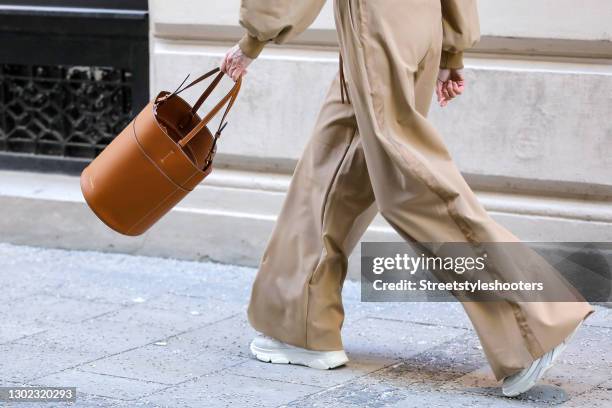 White sneaker by Copenhagen Studios and a brown bag by Brunello Cucinelli as a detail of influencer Annette Weber during a street style shooting on...