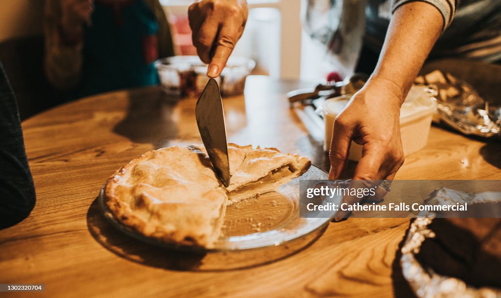Woman cuts a slice of Warm Apple Pie