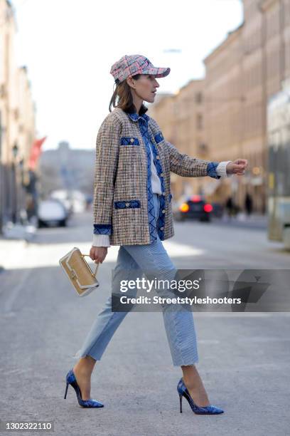 Influencer Annette Weber wearing a beige bast bag with gold and white details by Weat, a multicolored jacket with blue denim jeans details by Sandro,...