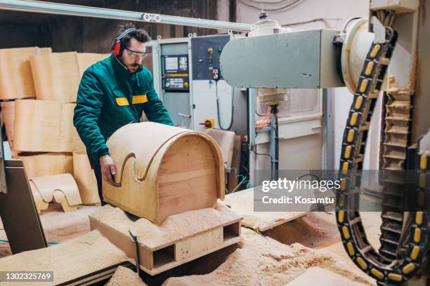 nachdem die cnc-maschine schneiden sie die form, wenn ein stuhl, schreiner bewegt es, um andere block zum schneiden setzen - cnc machine for wood stock-fotos und bilder