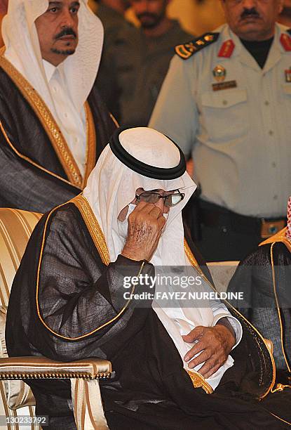 Ailing Saudi King Abdullah bin Abdel Aziz wears a surgical mask and wipes a tear as he prays during the funeral of his brother, the late Saudi Crown...