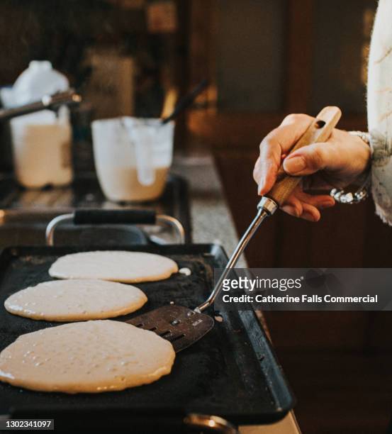 woman making pancakes on a grill - rijzen stockfoto's en -beelden