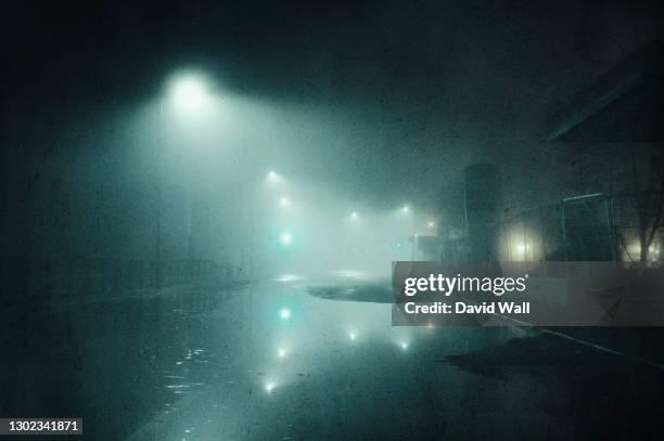 a moody concept of a flooded road with street lights on a foggy winters night in a city. with a grunge, artistic, edit - flood city stock pictures, royalty-free photos & images