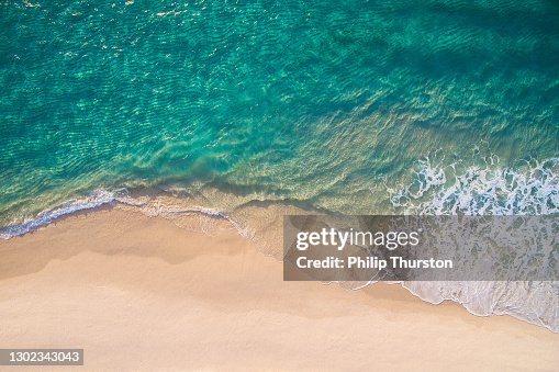 Schone oceaangolven die op wit zandstrand met turkoois smaragdkleurig water breken Schone oceaangolven die op wit zandstrand met turkoois smaragdkleurig water breken