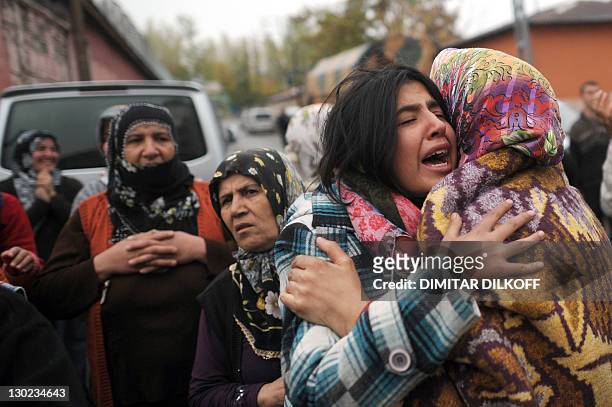 Relatives of quake victims react as rescue workers take part in an operation to salvage people from a collapsed building after an earthquake in Ercis...