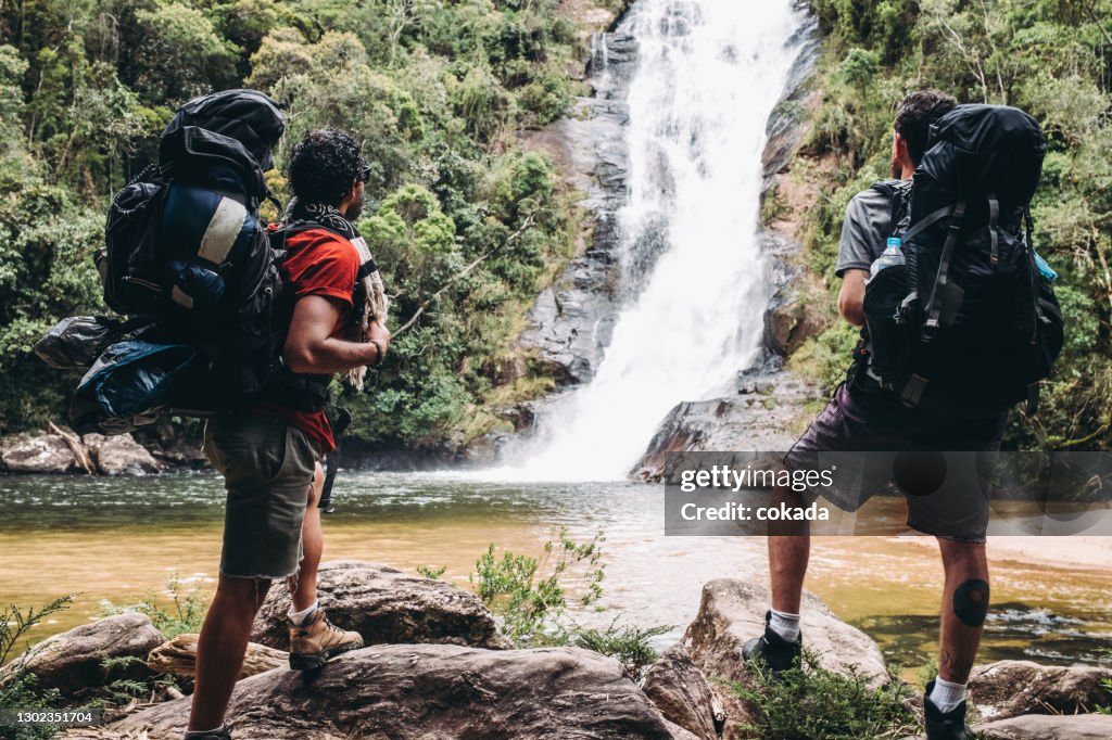 Backpacker hikers looking at a waterfall