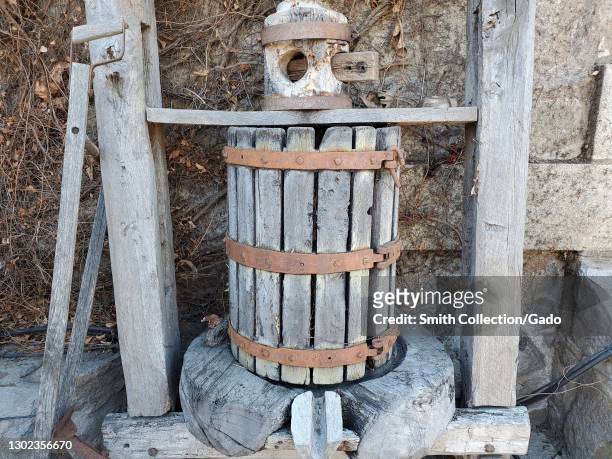 Close up of a weathered wooden wine press on display in a garden area at Vittorio's Estate Vinyard in St Helena, in Napa Valley, California, February...