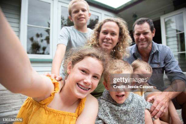 a family of six take a selfies outside their home - new zealand yellow stock pictures, royalty-free photos & images