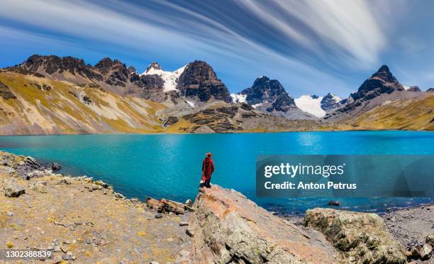 traveler in a poncho on the background of condoriri peak in cordillera real, andes, bolivia - bolivia stock pictures, royalty-free photos & images