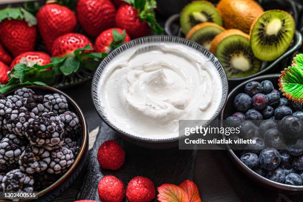 greek yogurt in a glass jars with spoons,healthy breakfast with fresh greek yogurt, muesli and berries on background. - probiotic stock pictures, royalty-free photos & images